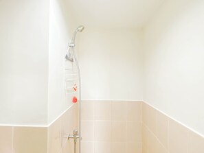 Ducha con cabezal de ducha de mano y llave instalada en la pared.