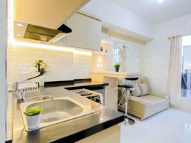 Una cocina moderna con un lavamanos, encimera y zona de comedor con sofá y sillón.