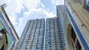 Ein Hochhaus mit einer gemusterten Fassade und mehreren Balkonen.