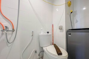 Un bany amb vàter, dutxa i acumulador d'aigua.