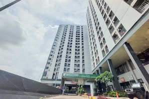Un grattacielo con un cartello che riporta la scritta 'Welcome to Smart Living at Serpong Green'.