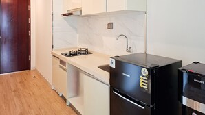 Una cocina moderna con estufa integrada, lavamanos y refrigerador negro.