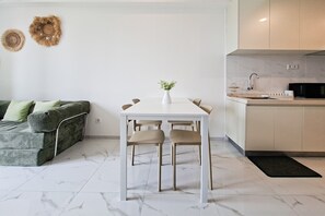 A modern kitchen with a white countertop, a black microwave, and a sink. - 3 Pax Tranquil 2Br At Sky House Bsd Apartment (Pagedangan)