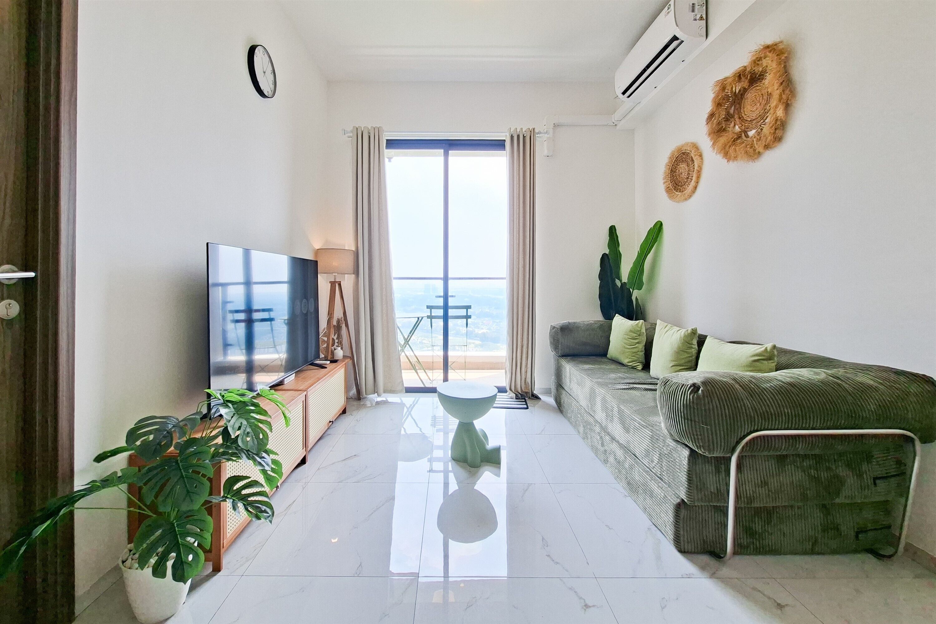 Una sala de estar moderna con televisor de pantalla plana, un sofá, una mesa de centro y una planta en maceta.