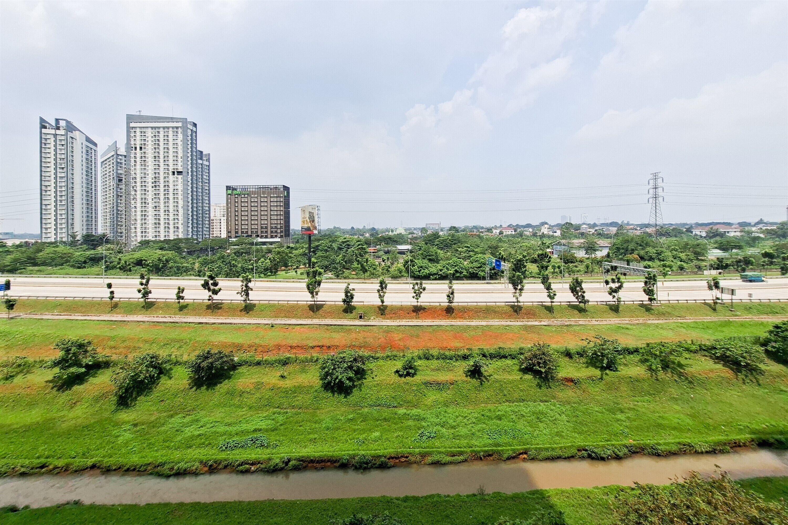 A cityscape with high-rise buildings, a highway, and a river.