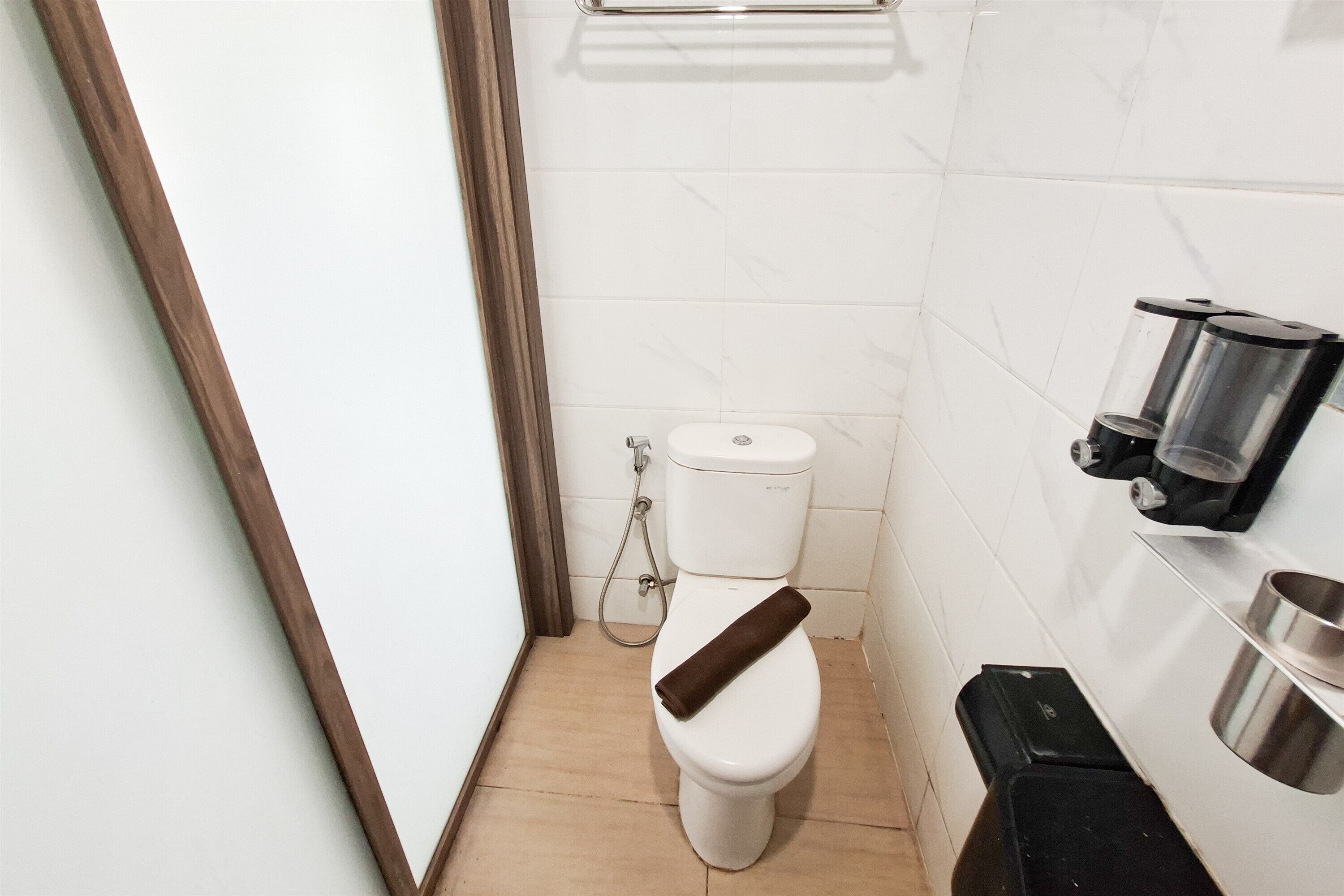 A small bathroom with a toilet, a shower, and a sink with a faucet.