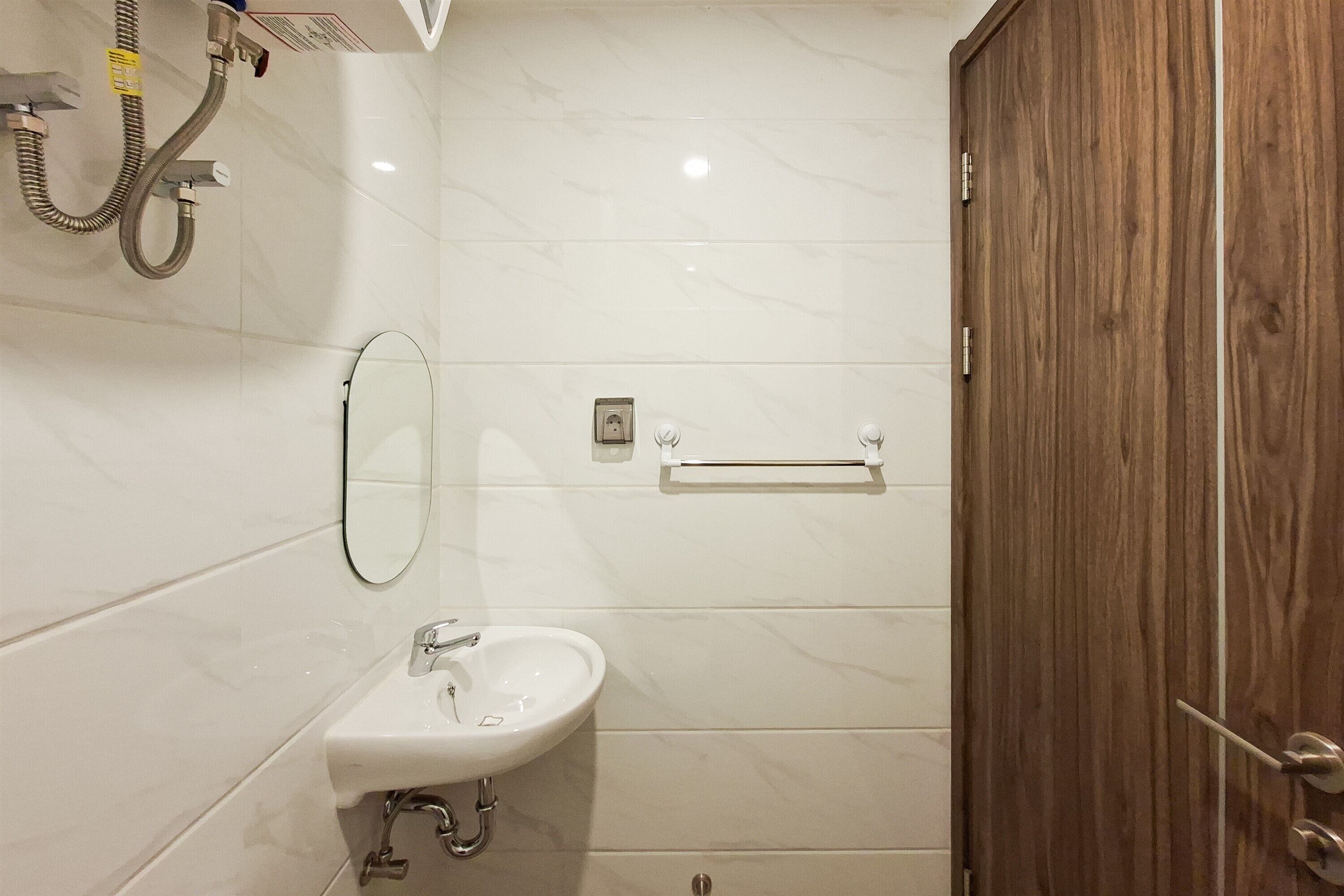 A bathroom with a white sink, mirror, and shower.
