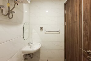 A bathroom with a white sink, mirror, and shower. - Studio Apartment With Functional Design At Sky House Bsd (Pagedangan)