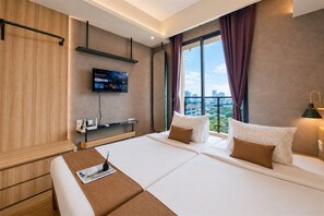 Ett hotellrum med en säng, en tv som är monterad på väggen, ett fönster med gardiner och utsikt över staden.