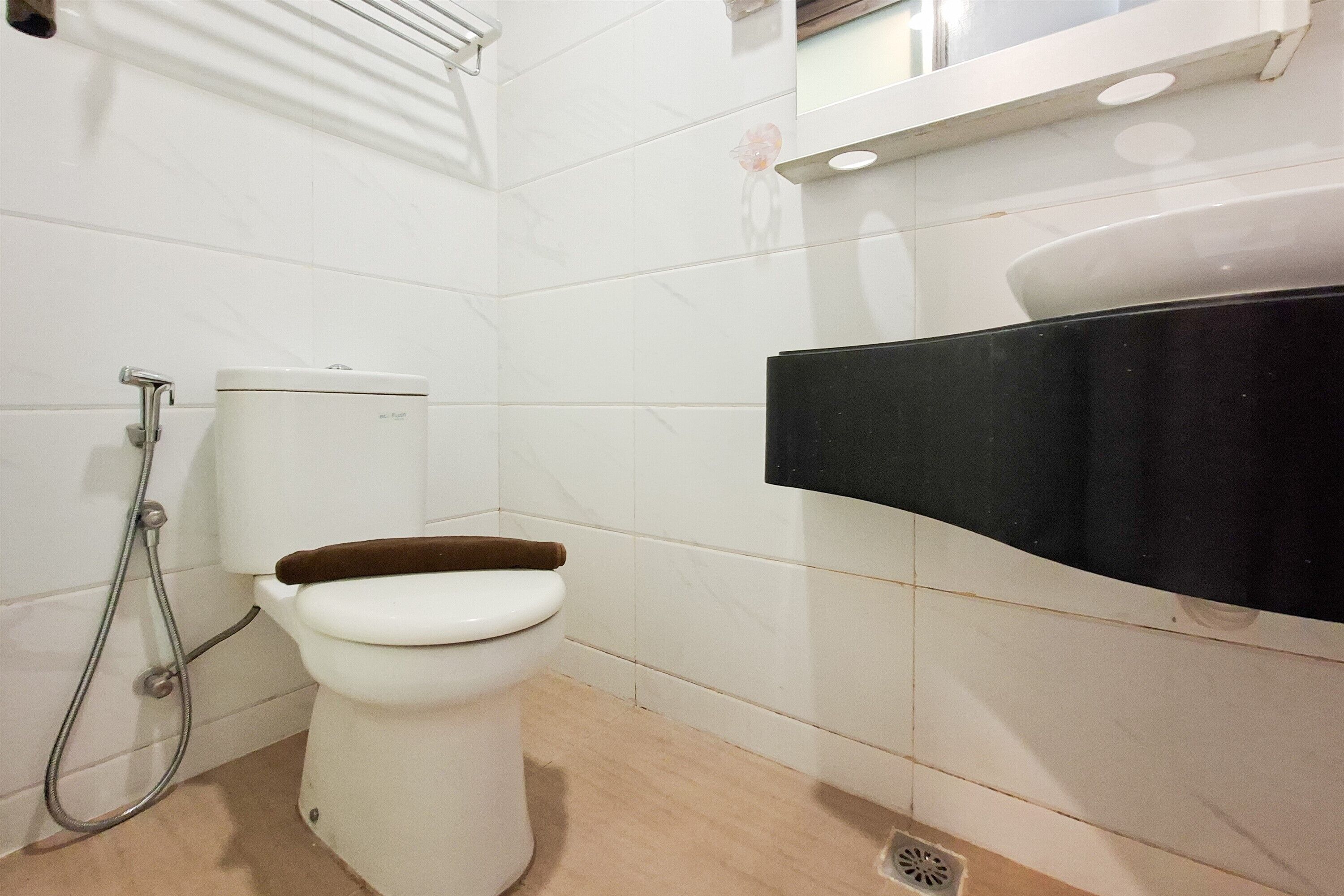 Une salle de bain avec des toilettes, une douche et un lavabo noir.