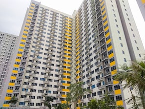 Um edifício residencial alto, com várias sacadas e fachada uniforme.