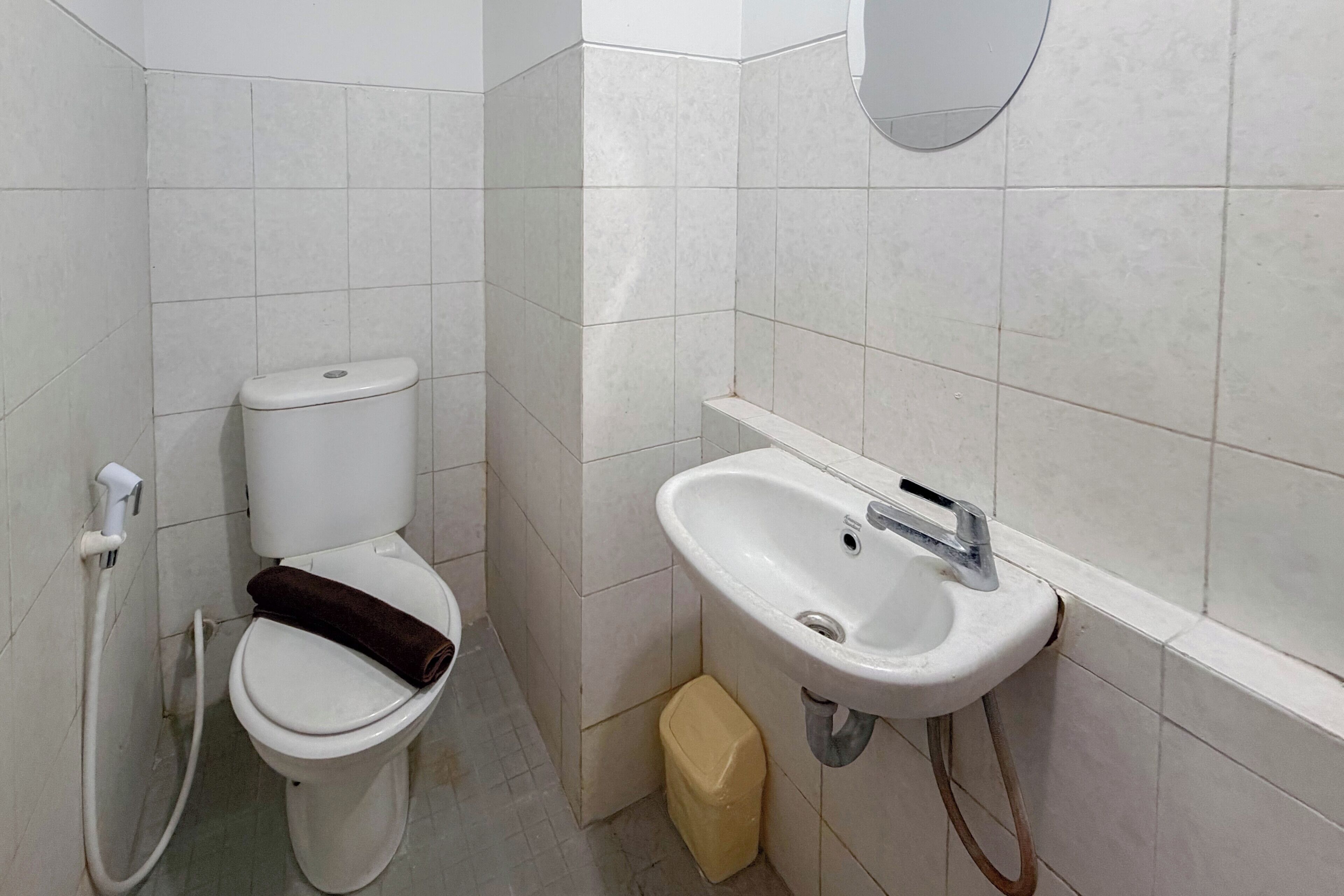 Un baño con inodoro, lavamanos y dispensador de papel higiénico.