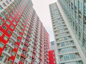 Ein Hochhaus mit zahlreichen Balkonen und einer rot-weißen Fassade.