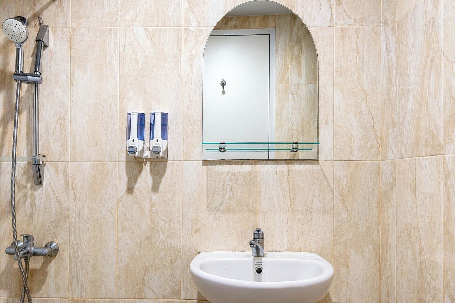 A bathroom with a shower, a sink, and a mirror above the mirror.
