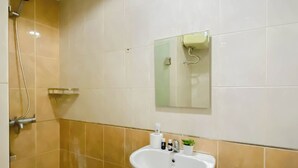A bathroom with a shower, a sink, and a mirror. - 2 Pax Serene Studio At Tamansari Sudirman Apartment (Jakarta)