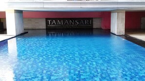 A swimming pool with a sign reading "TAMANSARI Executive Residence." - 2 Pax Serene Studio At Tamansari Sudirman Apartment (Jakarta)