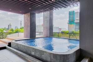 Ein Pool auf dem Dach mit Blick auf umliegende Gebäude und Grünflächen.