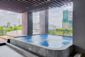 Ein Pool auf dem Dach mit Blick auf umliegende Gebäude und Grünflächen.