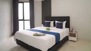 Una habitación de hotel moderna con una cama grande, una mesita de noche, una ventana con cortinas y vistas al exterior.
