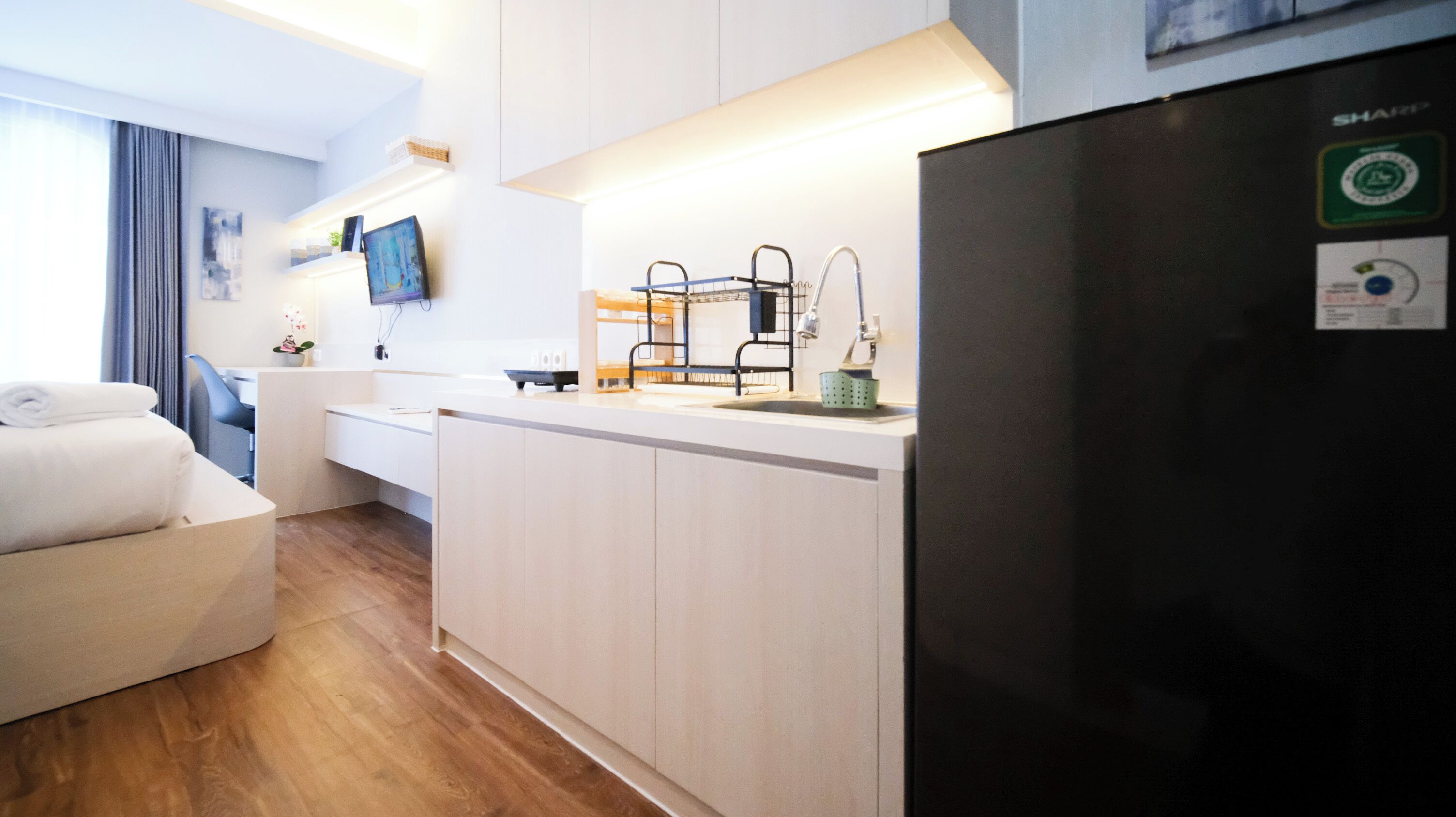 Una cucina moderna con frigorifero, lavello e zona pranzo con una sedia e un tavolo.