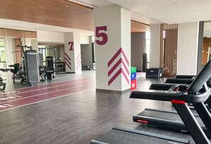 A gym with treadmills, weight machines, and a running track.
