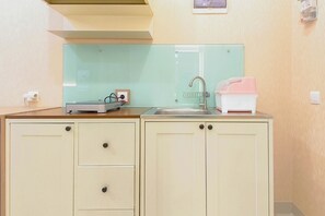 A kitchenette with a sink, a countertop, and cabinets.