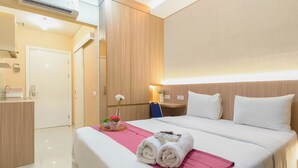 Een hotelkamer met een bed, bureau, stoel, kaptafel en spiegel.