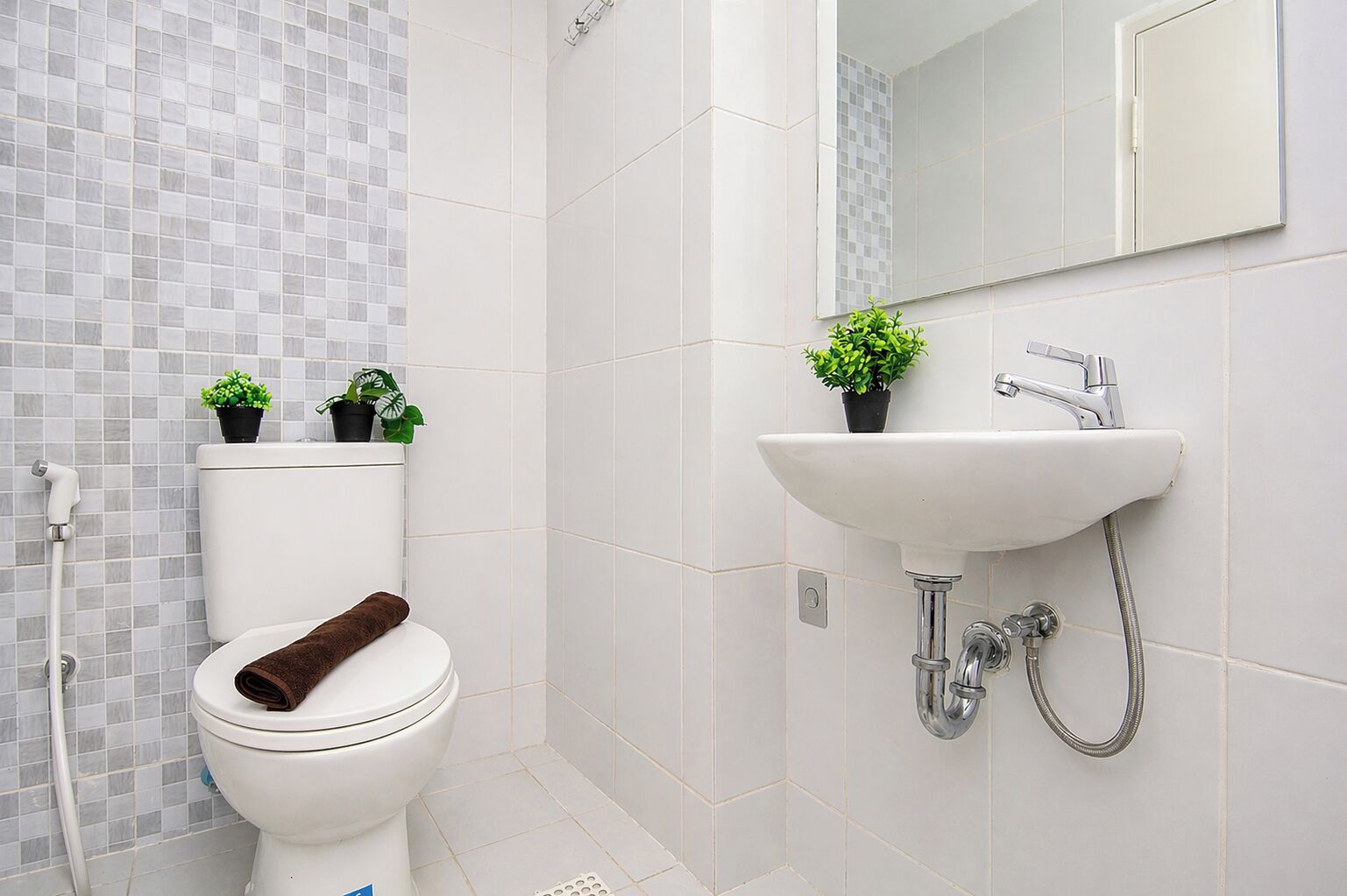A bathroom with a toilet, a sink, and a mirror.