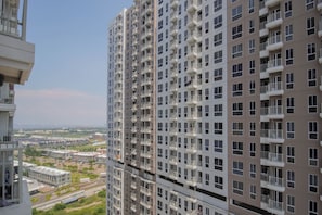 A high-rise residential building with multiple balconies, a clear view of the surrounding area, and a modern architectural design. - Compact Style Studio Apartment At Tokyo Riverside Pik 2 Near Nice (Teluknaga)