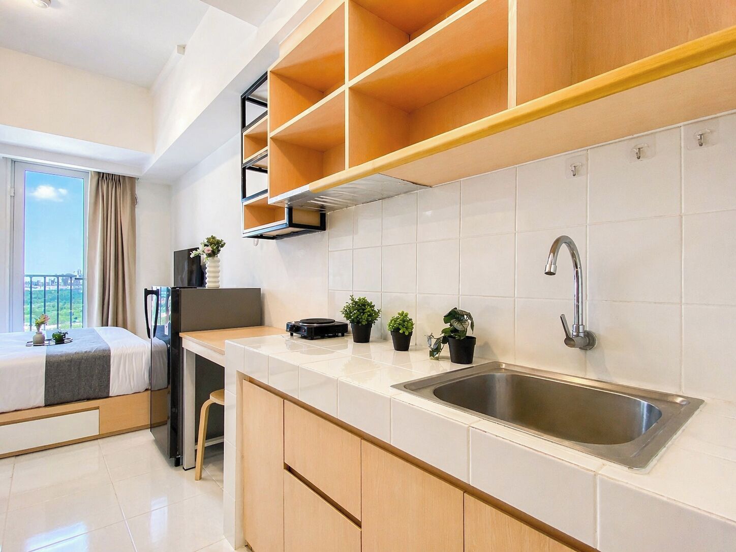 Una cucina moderna con lavello integrato, mobili in legno e un balcone con vista.