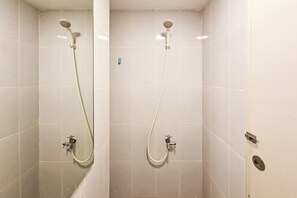 A bathroom with two showerheads, white tiled walls, and a visible drain. - Good Studio Apartment Tokyo Riverside Pik 2 Near Nice (Teluknaga)