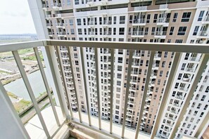 A high-rise residential building with multiple balconies and a river view. - Good Studio Apartment Tokyo Riverside Pik 2 Near Nice (Teluknaga)