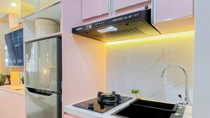 A modern kitchen with a built-in refrigerator, a stove, and a sink. - Airy Studio Apartment At Transpark Juanda Bekasi Timur (Bekasi)