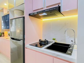Una cocina moderna con refrigerador empotrado, estufa y lavaplatos.