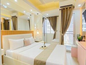 A modern hotel room with a large bed, bedside tables, a mirror, and a view of the outside. - Airy Studio Apartment At Transpark Juanda Bekasi Timur (Bekasi)