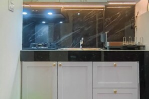 Een moderne keuken met een zwart aanrecht, een spoelbak en een afzuigkap.