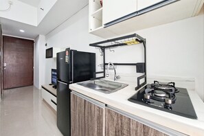 A modern kitchen with a built-in refrigerator, a stove, a sink, and a microwave. - Practical 1Br For 2 Pax At Vittoria Residence (Jakarta)