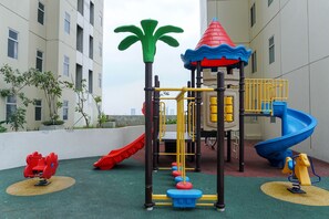 Ein Spielplatz mit Rutsche, Klettergeräten und einem Turm.