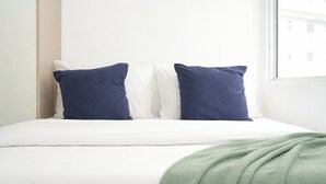 A bed with white bedding, two pillows, and a green throw blanket. - Homey And Best Place 2Br At Apartment Vittoria Residence (Jakarta)