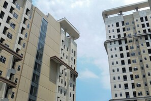En hög byggnad med många våningar, stora fönster och en modern arkitektonisk design.
