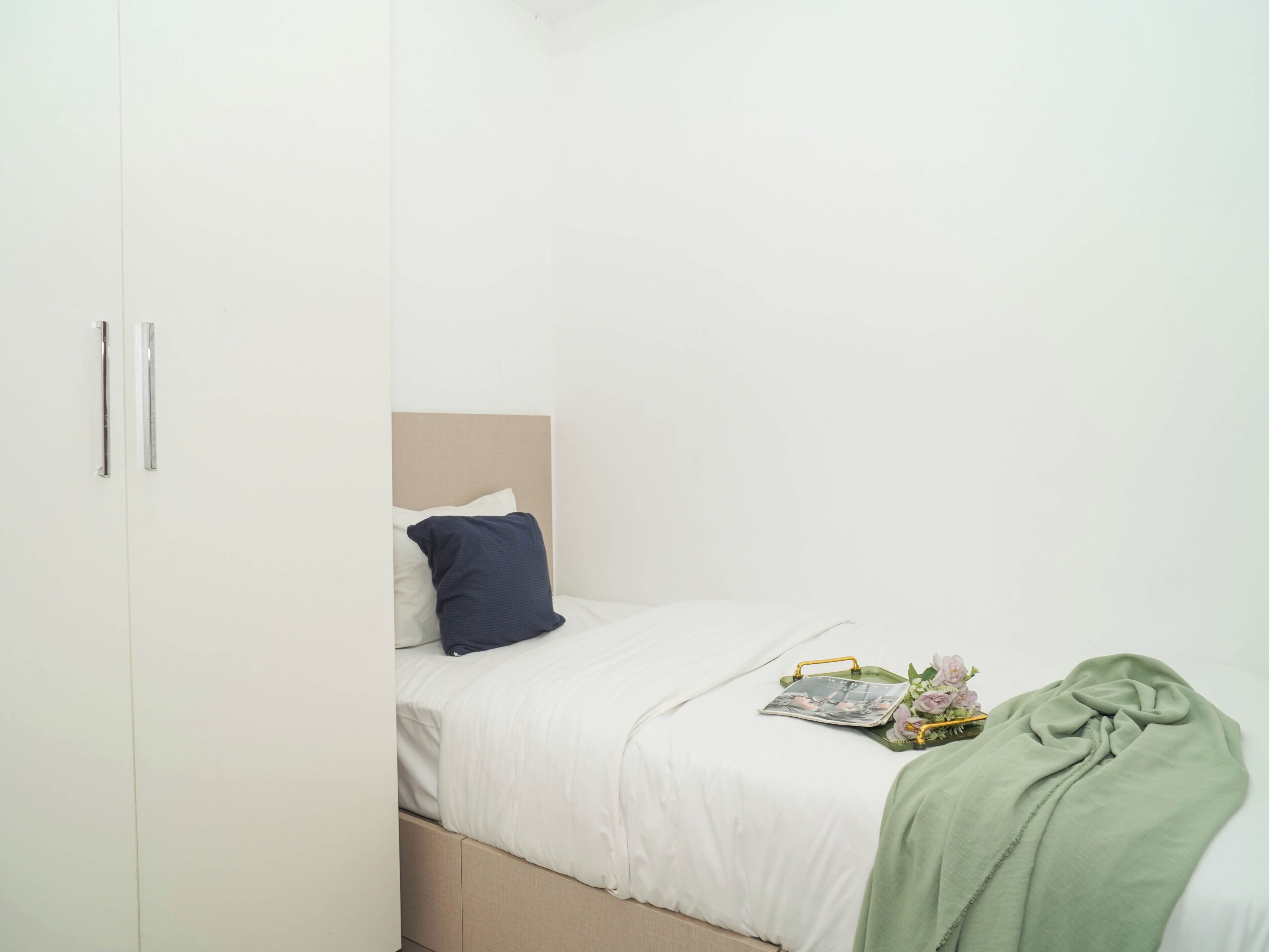 A bedroom with a bed, a bedside table, and a wardrobe.