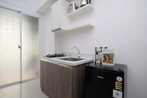 Eine moderne Küche mit Gaskochfeld, Spüle und einem schwarzen Kühlschrank.