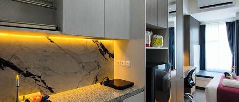 A modern kitchen with a marble backsplash, built-in appliances, and a countertop with a sink.
