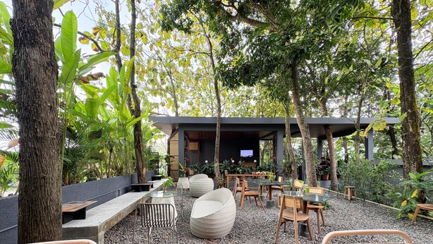 An outdoor seating area with wicker furniture, a TV screen, and a covered seating area. - Guru Giri Forest Cabin Villa 2BR for 8 Pax (Include Breakfast) (Srimulyo)