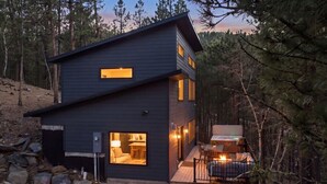 A modern two-story cabin with a deck, surrounded by trees. - Cloudview Lodge  Retreat (Rapid City)
