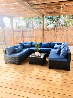 Ein überdachter Außenbereich mit Ecksofa und kleinem Tisch.