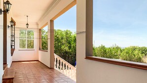 A corridor with tiled flooring, a balcony with a railing, and large windows offering a view of greenery. - 3 bedroom lovely home in Cantillana (Cantillana)