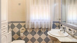 A bathroom with a toilet, sink, and mirror. - 3 bedroom lovely home in Cantillana (Cantillana)