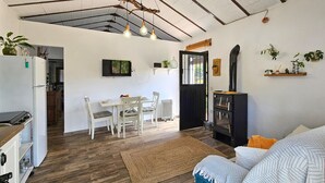A compact living space with a dining area, kitchenette, and a cozy seating area with a sofa and a coffee table. - Amazing home in Yunquera (Yunquera)