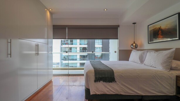 Ein Schlafzimmer mit einem großen Bett, einem Balkon mit Blick und einem Bild an der Wand.